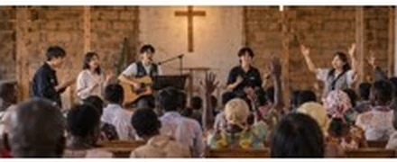 십자가가 있는 작은 실내에서 음악을 연주하고 모임에 참여하는 사람들